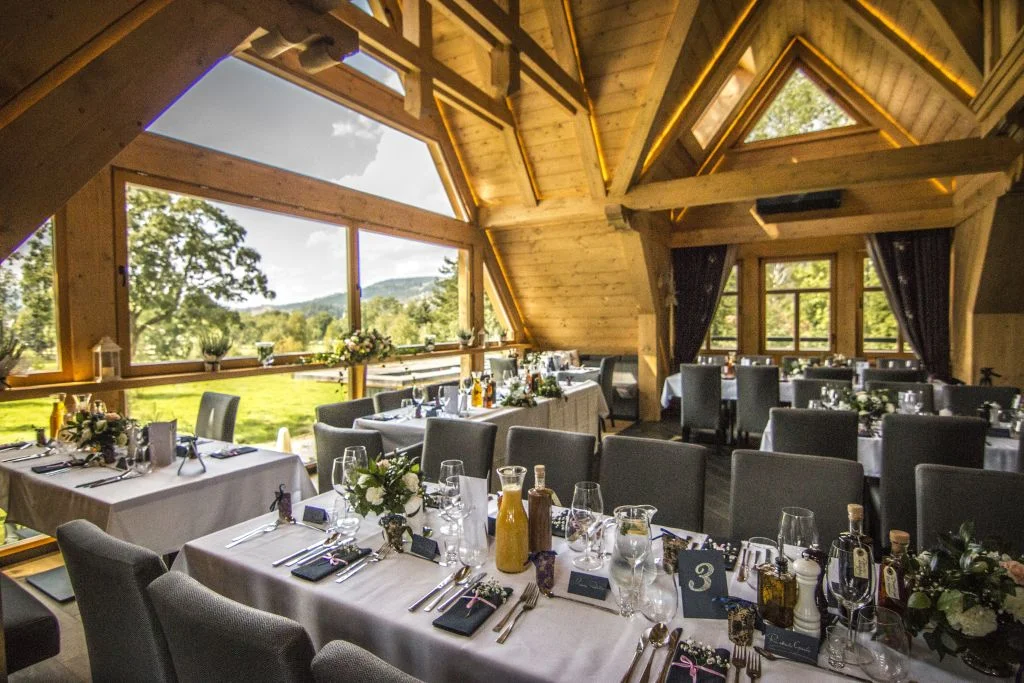 Sala na poddaszu Villa Toscana z dużymi oknami, nakryta na przyjęcie