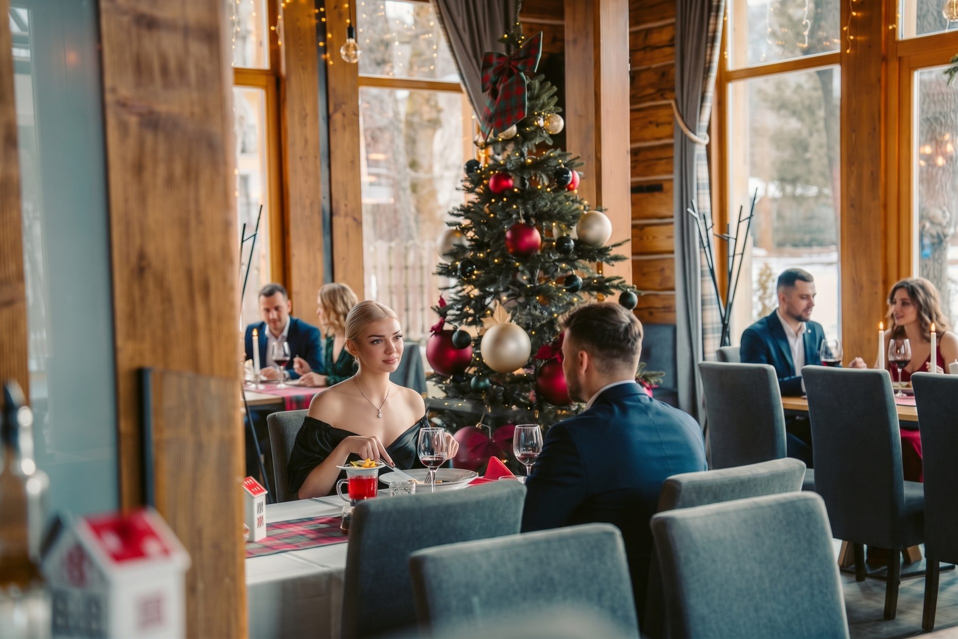 Goście przy wigilijnej kolacji obok choinki w restauracji Villa Toscana w Zakopanem