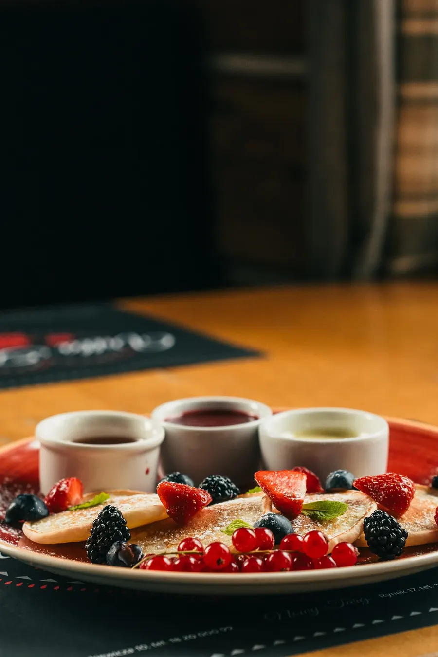 Pancakes z owocami, sosem truskawkowym i białą czekoladą